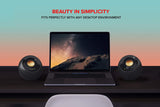 Laptop on a desk with two creative speakers on either side, against a gradient background with 'Beauty in Simplicity' text.